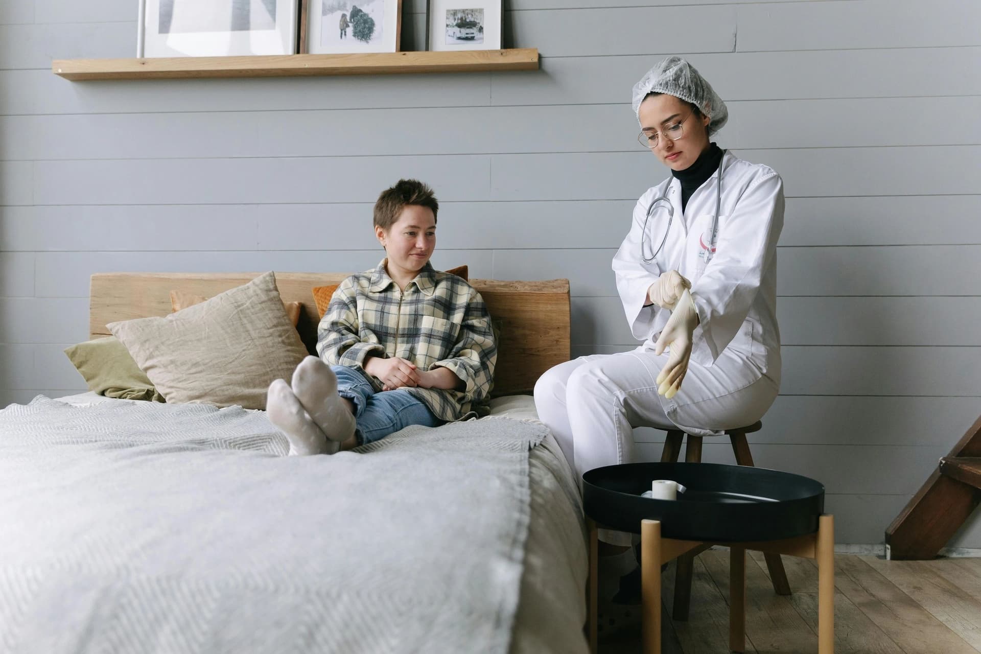 A home health nurse visiting a young boy sitting on his bed